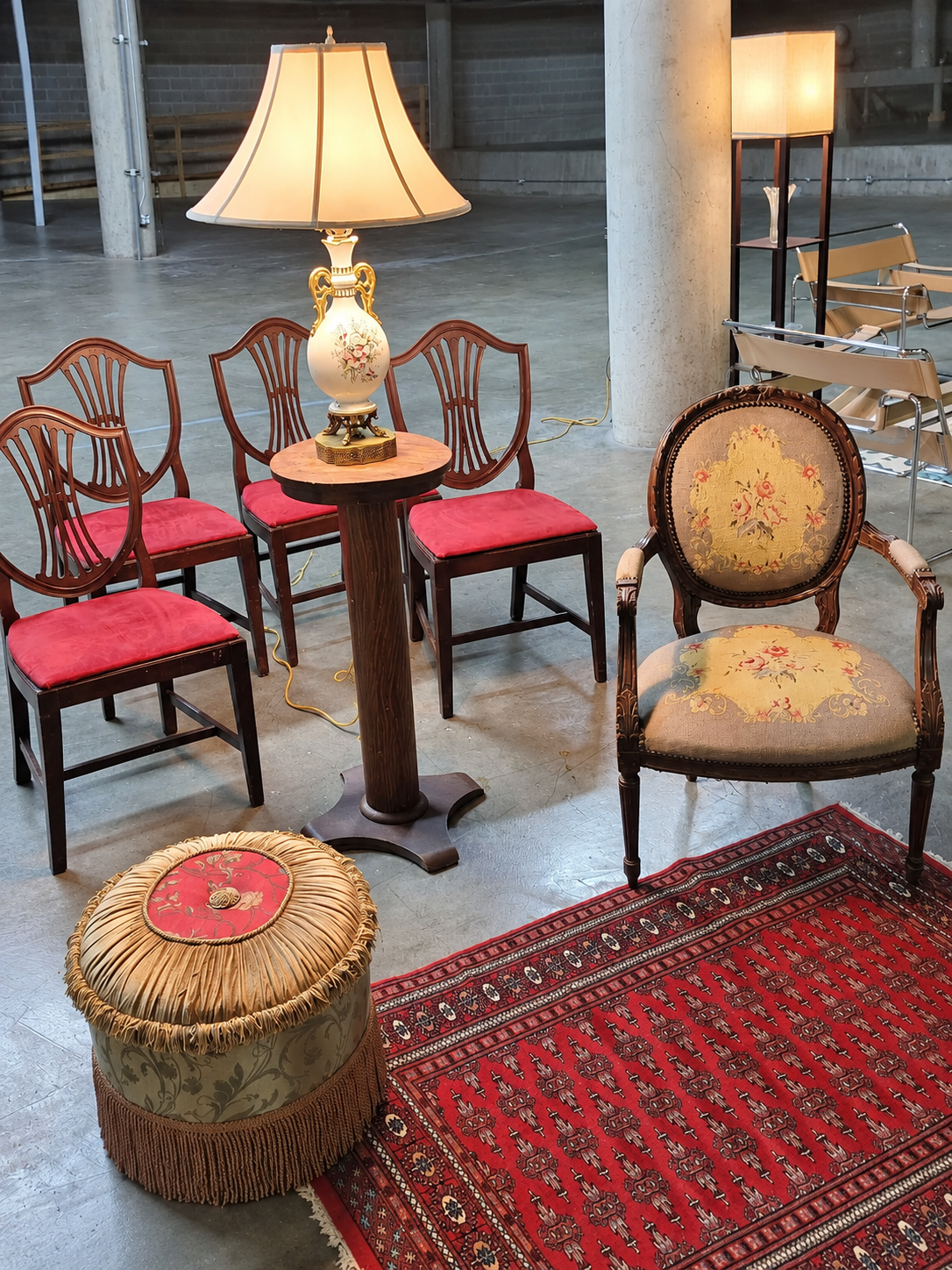 Vintage chairs, lamps, rugs, and an upholstered stool