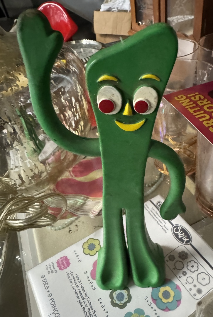 A Gumby collectible among the glassware
