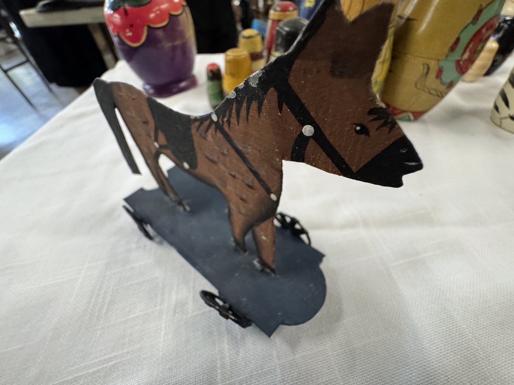 A wooden toy donkey on wheels